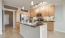 Spacious and well lit kitchen with wood floors and stainless steel appliances
